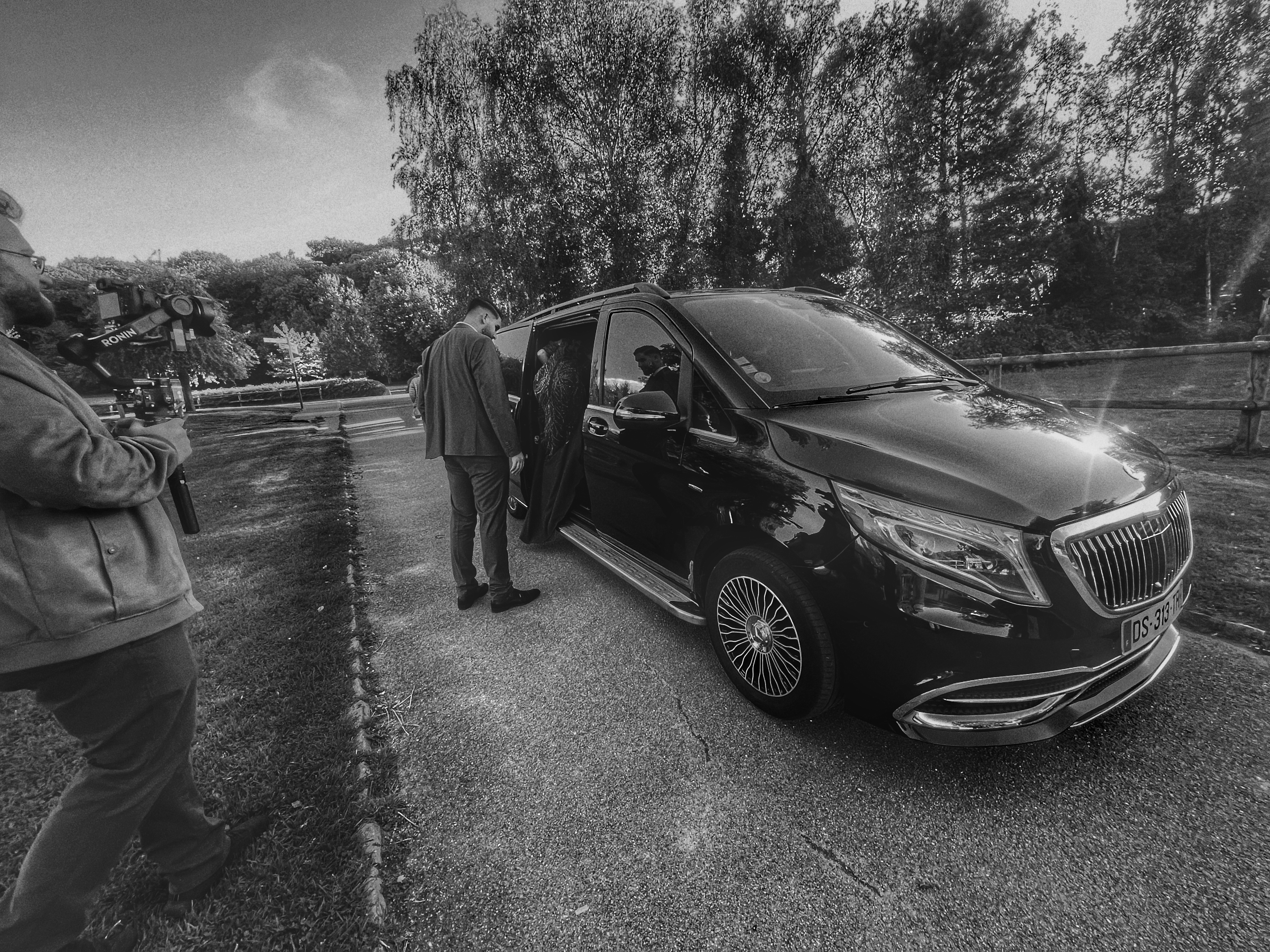 Chauffeur privé ouvrant la portière d'un van de luxe noir — Transport de groupes Allo Shuttle Le Havre